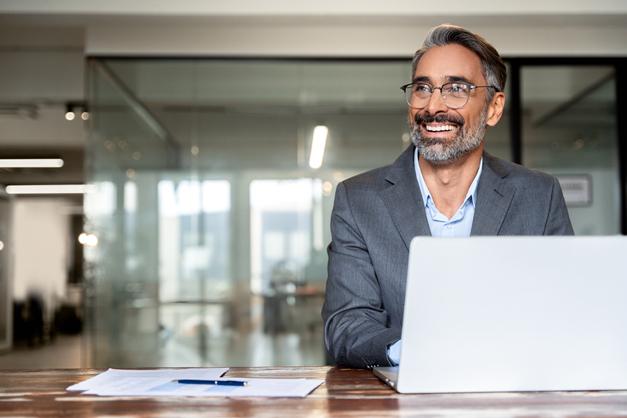 Man working on a computer and smiling in the office.