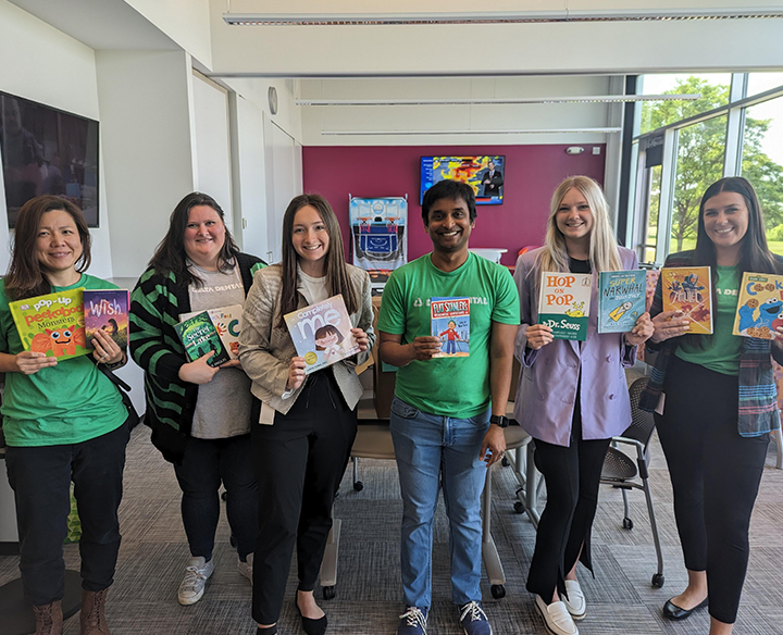 a group of people holding up books they're donating