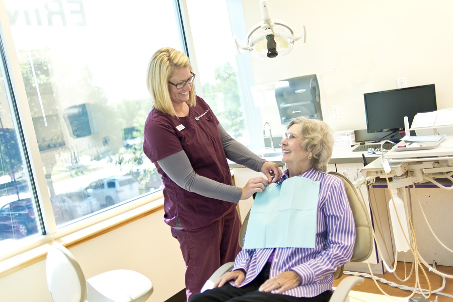 Dentist talking to patient sitting in dentist chair