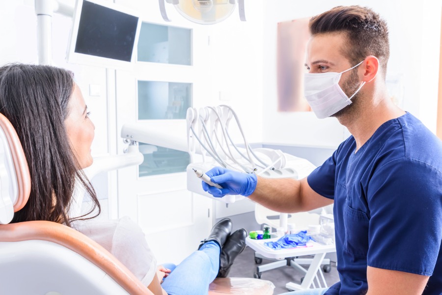 dentist talking to patient in dental chair