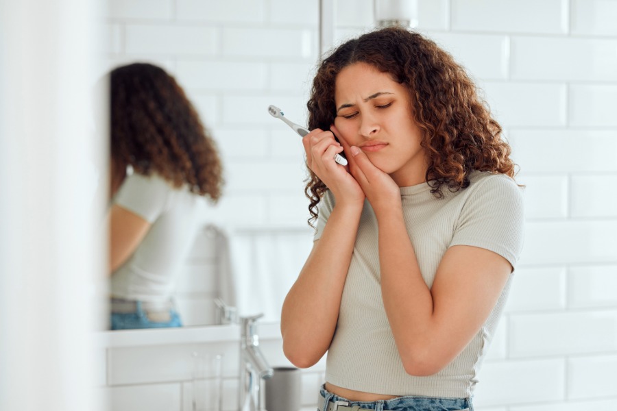 woman holding her jaw in pain