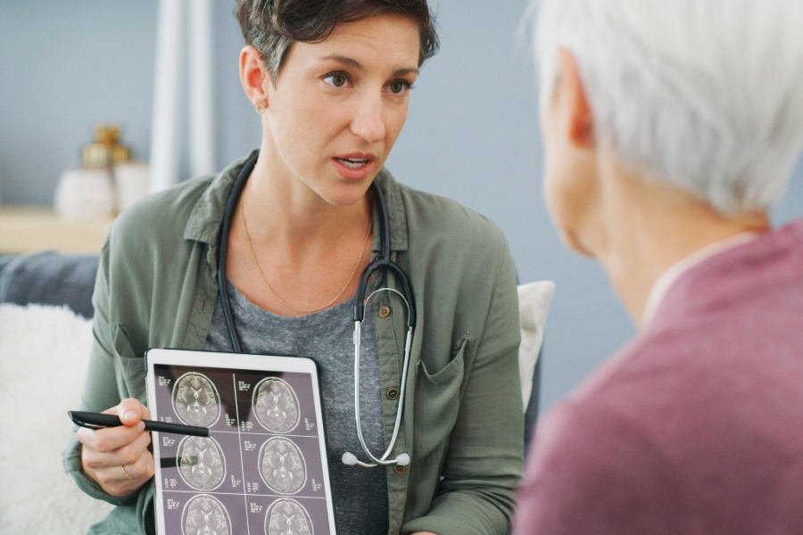 woman doctor showing brain scan images to a senior patient