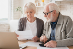 older couple looking at a laptop and calculator