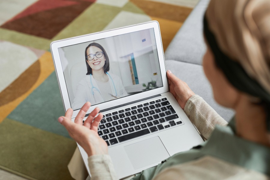 woman using a laptop to talk to a dental provider