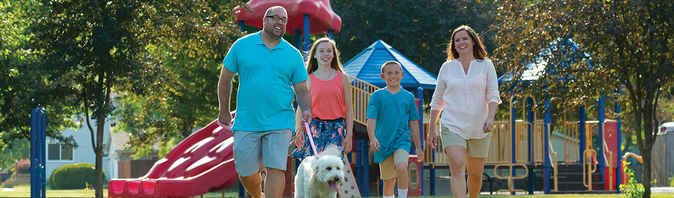 family walking dog in park