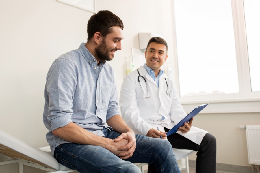 man sitting with doctor review a health report