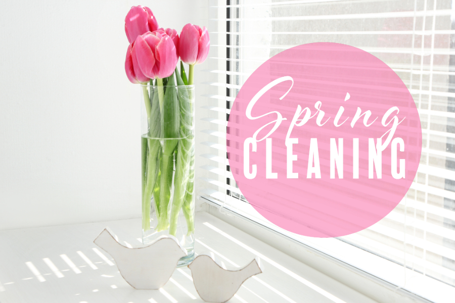 vase of pink tulips sitting next to a window with bright sunshine